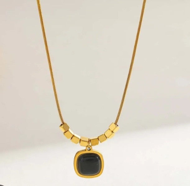 Square black pendant with golden necklace