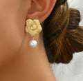 Floral drop earrings with a single dangling pearl